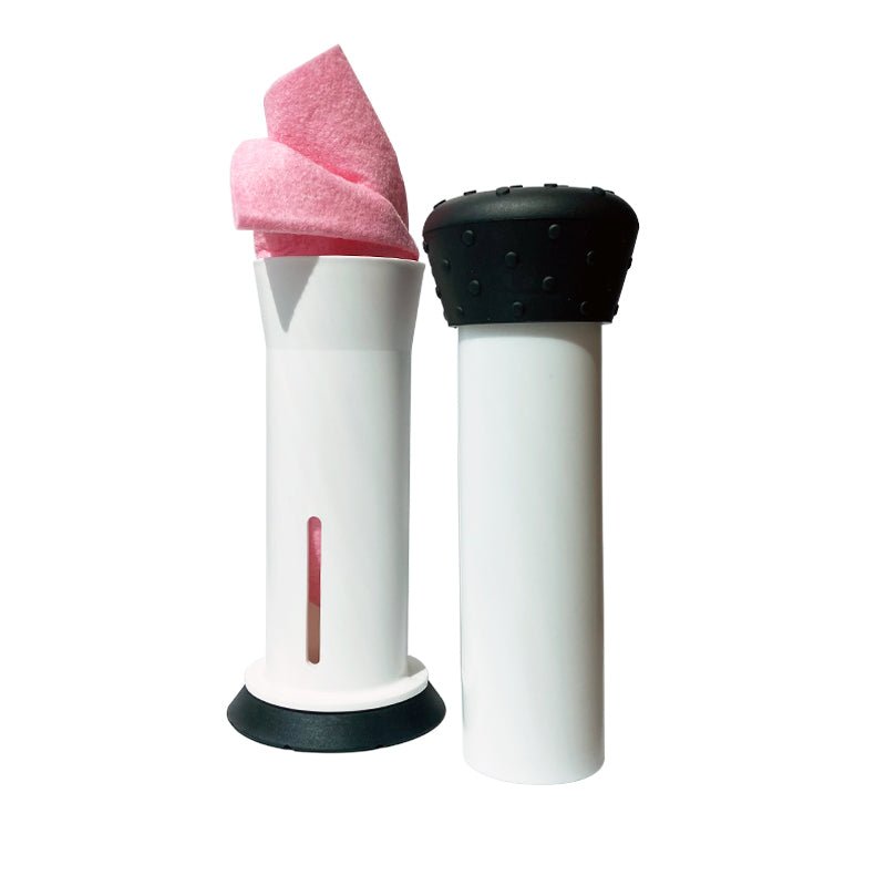 Vit disktrasepress med svart bas och den svarta pressdelen bredvid, med en rosa trasa i
