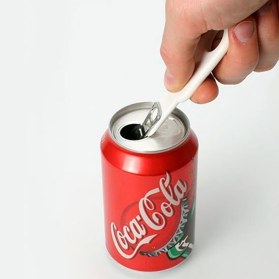 En hand använder den vita CanPop burköppnaren för att öppna en röd Coca-Cola burk