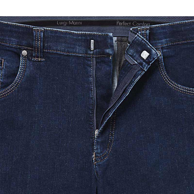 Nærbillede af lynlås og hægte på de mørkeblå jeans, med teksten "Luigi Morini Perfect Comfort" i linningen