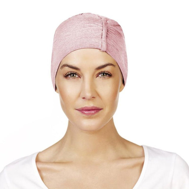 Kvinna bär en rosa Chandra nattmössa i bambuviskos, designad för känslig hud