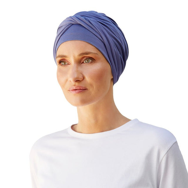 Kvinna med en stilren blå Shakti turban i mjuk bambuviskos, draperad för en fin passform