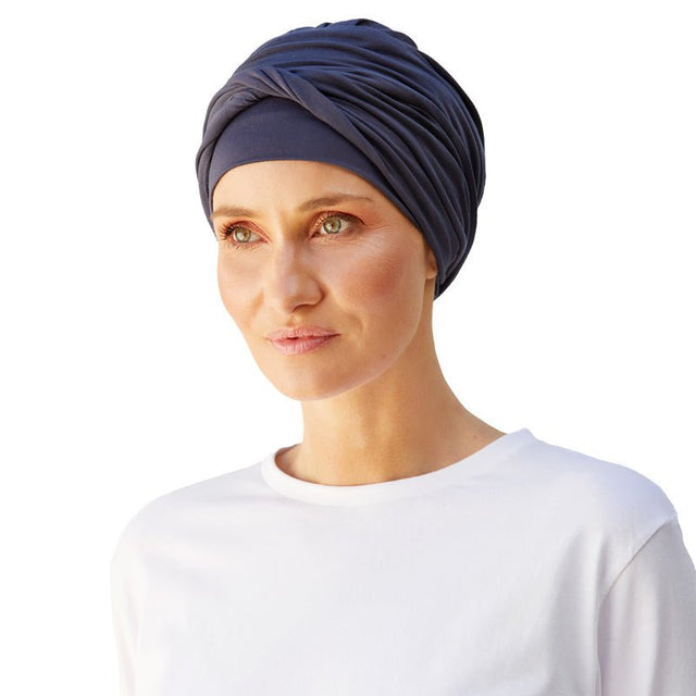 Kvinna bär en mörkblå Shakti turban i bambuviskos, elegant draperad med volym framtill