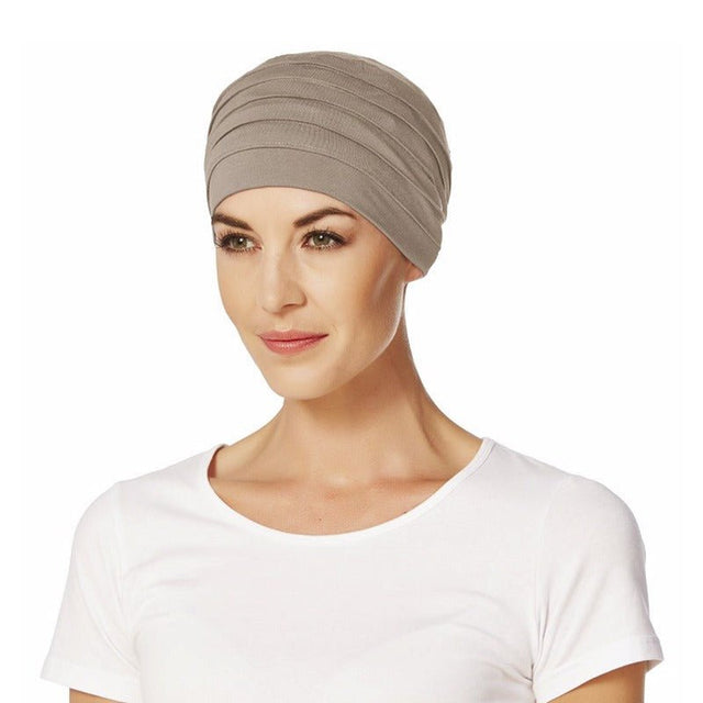 Modell med en beige yoga turban i mjuk bambuviskos, elegant veckad framtill