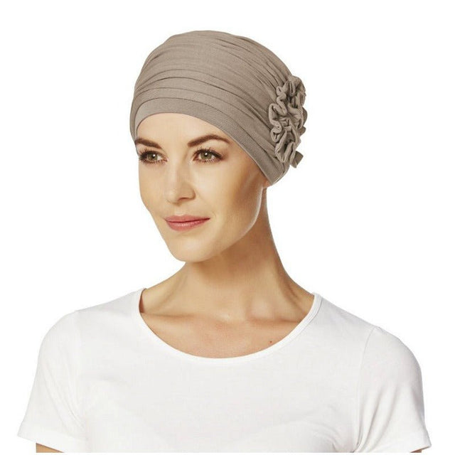 Kvinna med en elegant beige Lotus turban i bambuviskos, med veck och sidodetail