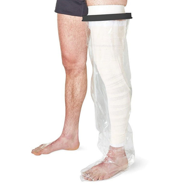 En person med ett vitt gips eller bandage på ena benet, täckt av ett transparent duschskydd för hela benet