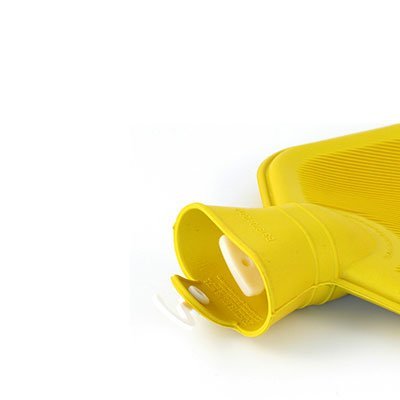 Närbild på öppningen av en gul värmeflaska med vit propp inuti