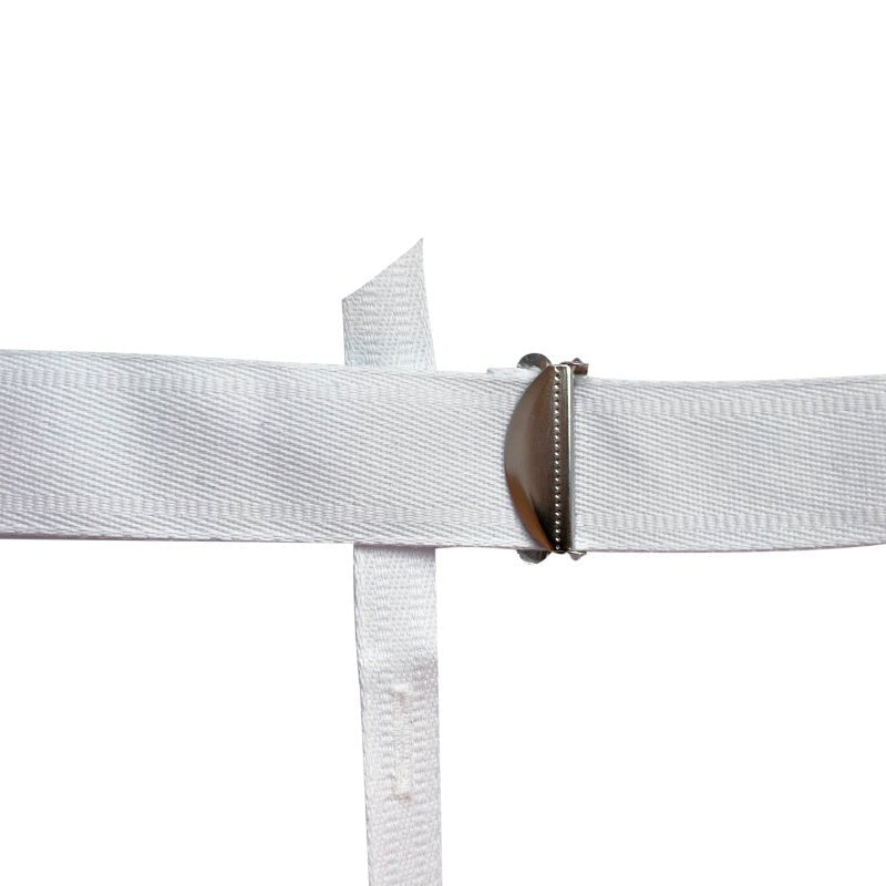 Detaljbild av det silverfärgade spännet på suspensoarens vita, justerbara höftrem