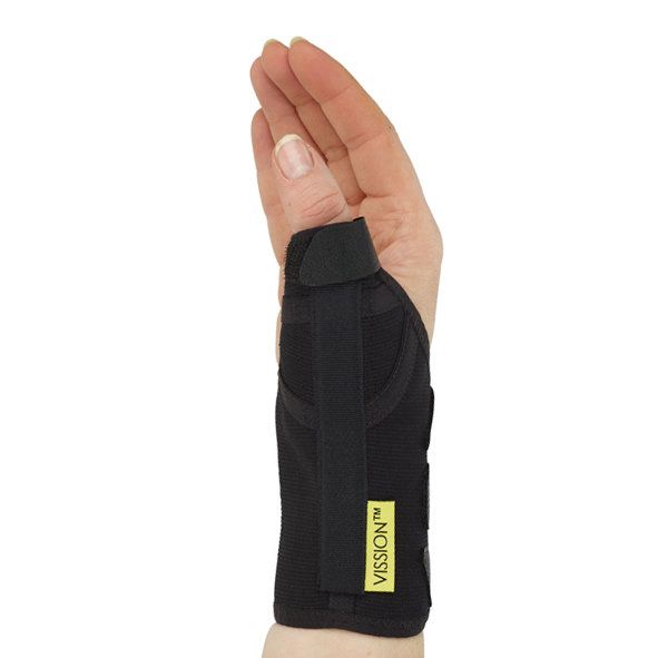 Sort tommelfingerbandage på en hånd, set fra håndryggen, der stabiliserer tommelfinger og håndled