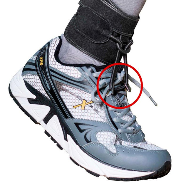 Fot i grå sneaker med Dictus droppfotsband, visar var krokarna fästs i skosnörena