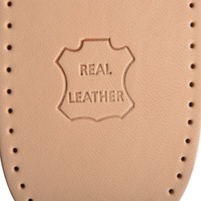 Nærbillede af et lysebrunt læder skoindlæg med præget "REAL LEATHER" logo