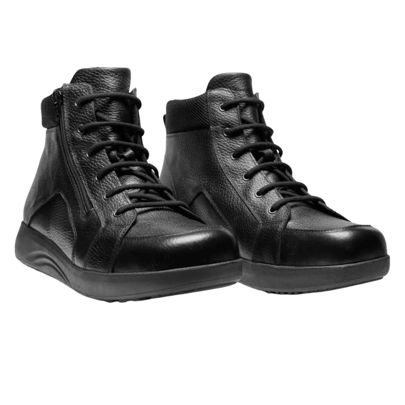 Ett par svarta New Feet herrkängor i läder med snörning och dragkedja, sedda snett framifrån