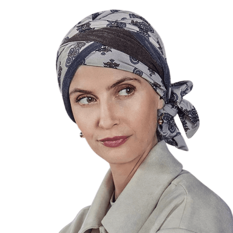Kvinna som bär Beatrice turban med paisleymönster i grå och bruna nyanser, knuten i nacken