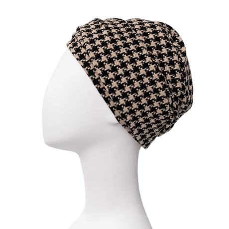 Lea turban i svart och beige hundtandsmönster på skyltdocka, sedd från vänster sida