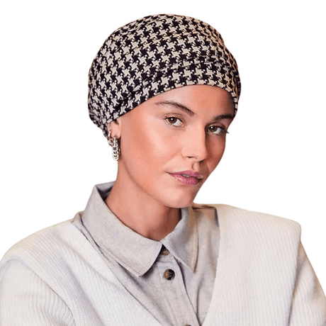 Kvinna med Lea turban i svart och beige hundtandsmönster, turbanen har naturlig volym framtill