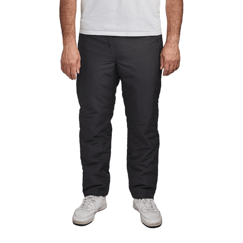 Svarta Dobsom termobyxor sedda framifrån på en person som står, med vita sneakers
