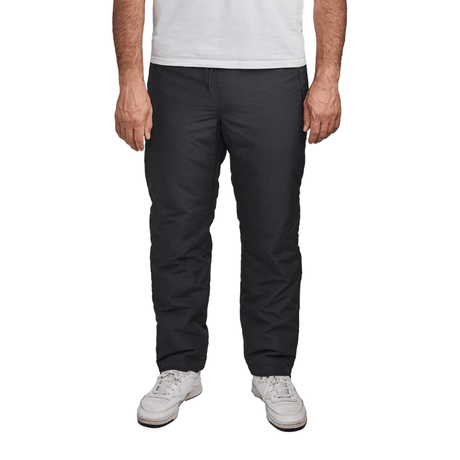 Svarta Dobsom termobyxor sedda framifrån på en person som står, med vita sneakers