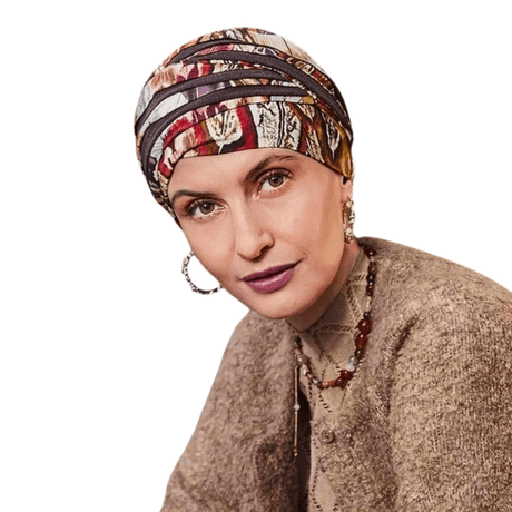 Kvinna bär Shanti turban i Tribal Feathers mönster med varma höstfärger, sedd snett framifrån