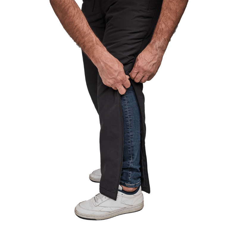 Närbild på händer som öppnar den delbara dragkedjan på svarta Dobsom termobyxor, över jeans