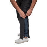 Närbild på händer som öppnar den delbara dragkedjan på svarta Dobsom termobyxor, över jeans